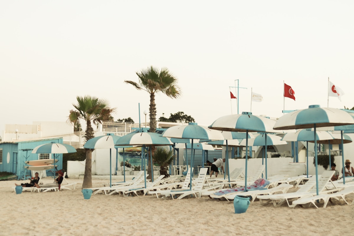 Aerial view of a Tunisian beach with straw umbrellas and turquoise Mediterranean water