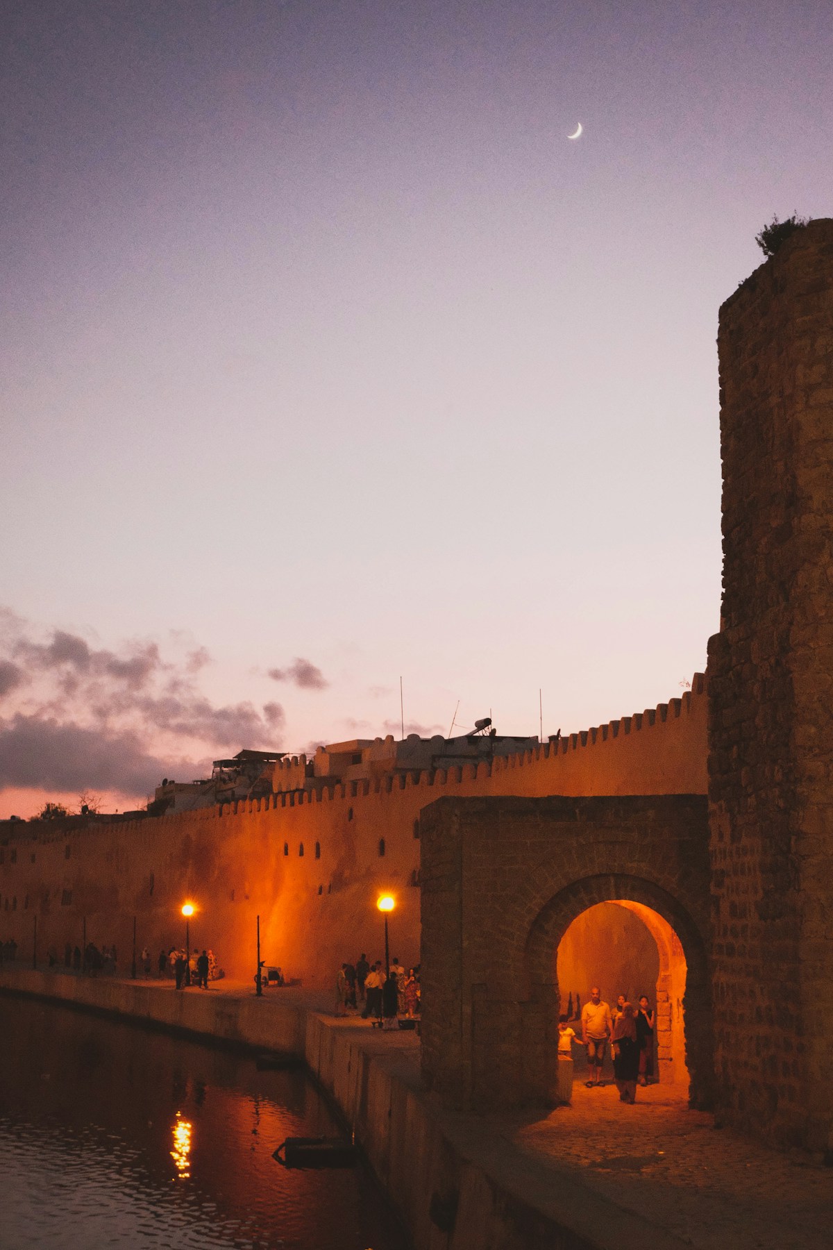 The illuminated ancient walls and arched gate of Bizerte medina at twilight, Tunisia
